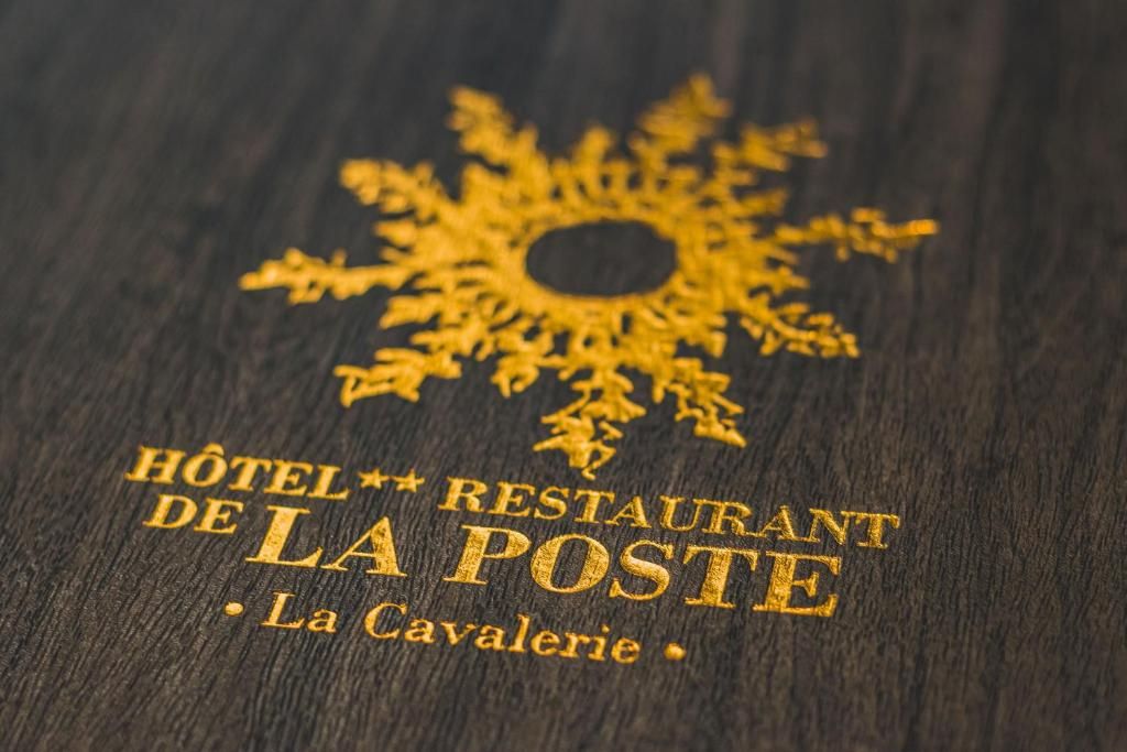 Une surface en bois portant en relief l’inscription suivante : « HÔTEL RESTAURANT DE LA POSTE, La Cavalerie. »