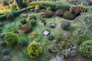 Stroll through a beautifully landscaped garden with neatly trimmed hedges and topiary shapes.