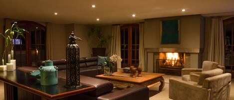 A living room with a fireplace, leather sofas, a coffee table, and decorative items.