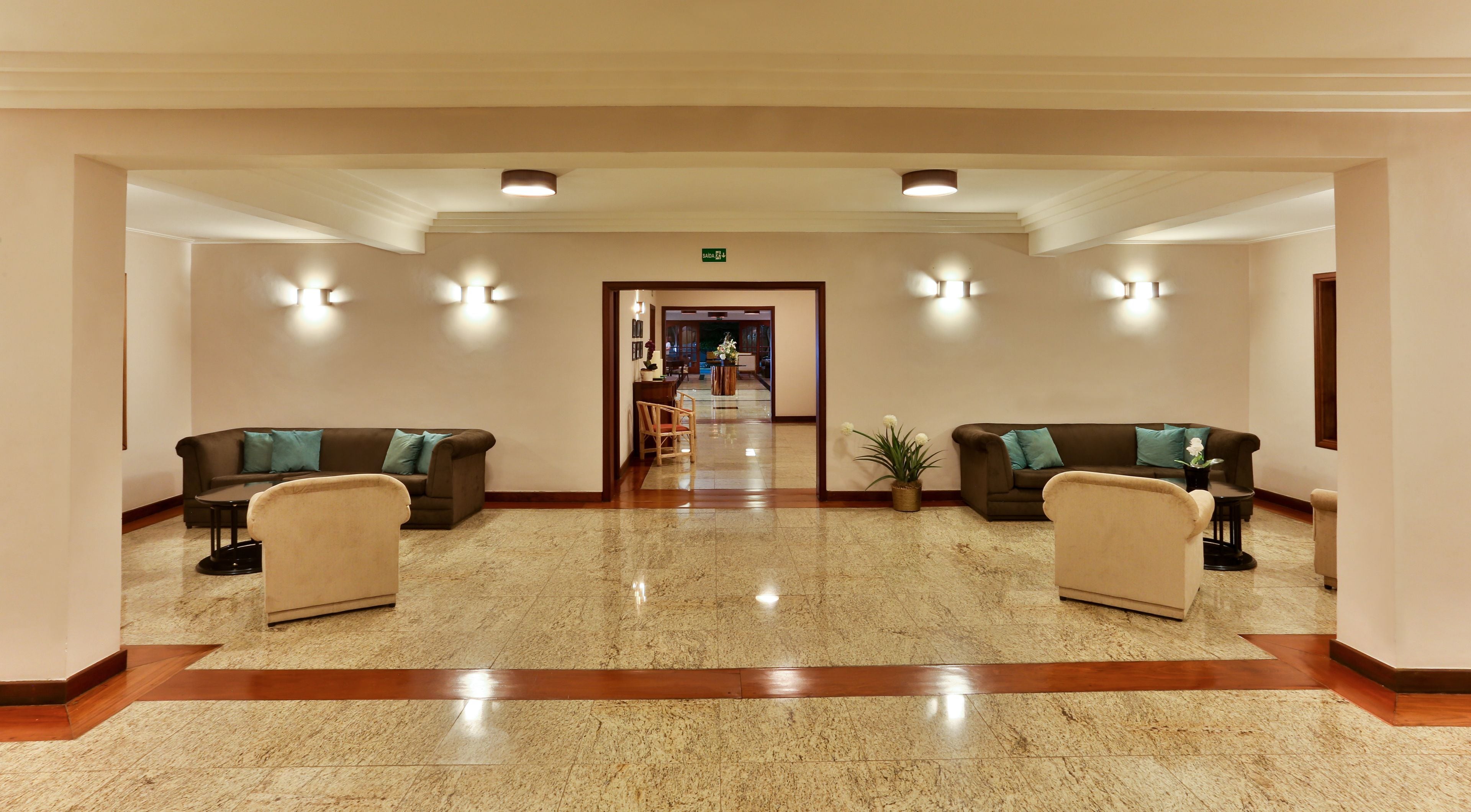 Un hall de hotel con dos sofás, una mesa de centro y una planta en maceta.