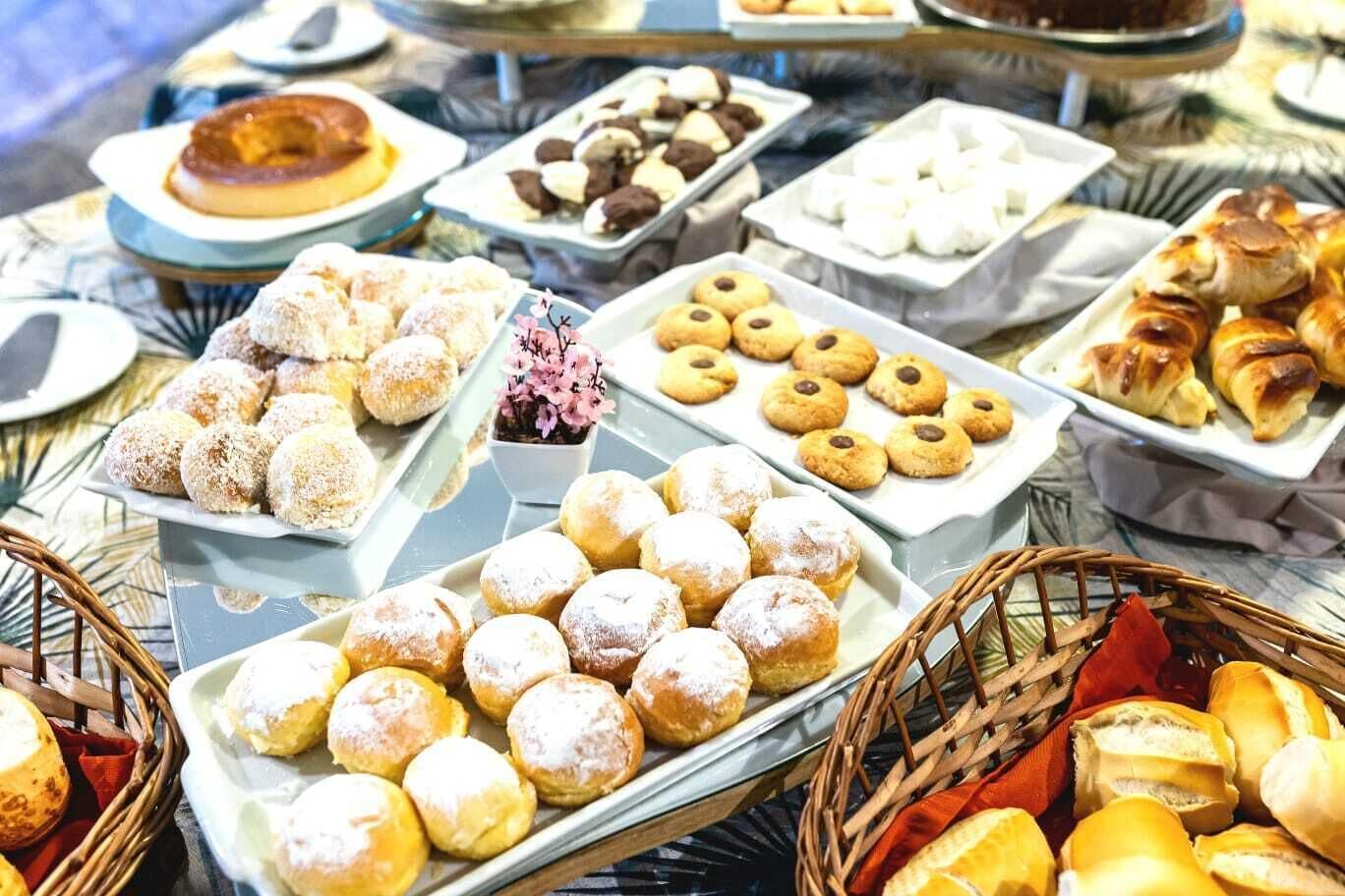 A buffet with various pastries and desserts, including doughnuts, cookies, and pastries.