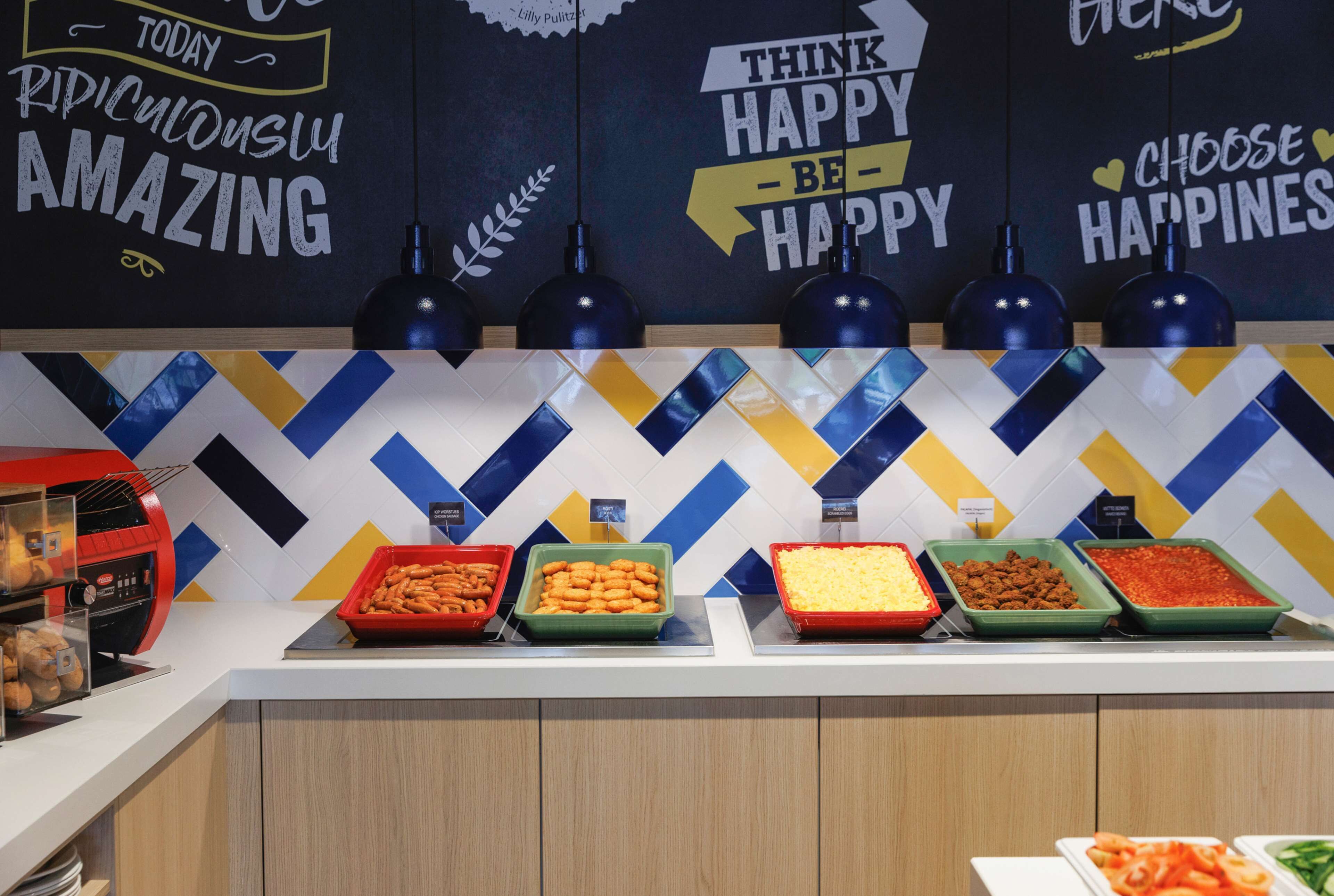 A buffet area with various food options and motivational wall art.
