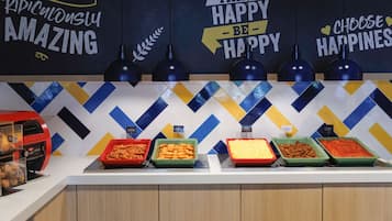 A buffet area with various food options and motivational wall art.