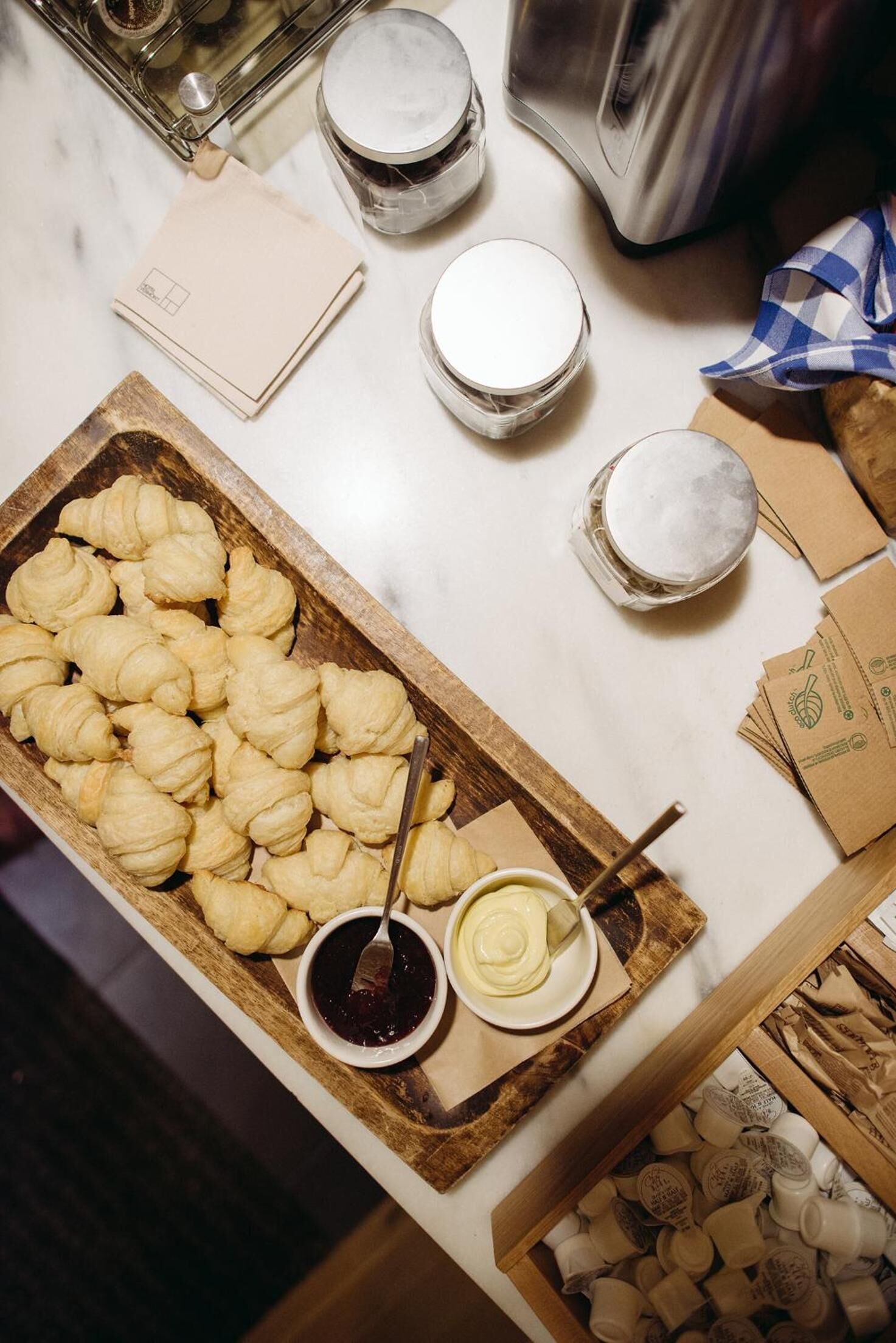 A kitchen counter with pastries, jars, and kitchen appliances.