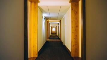 A long, narrow hallway with wooden walls and a carpeted floor.