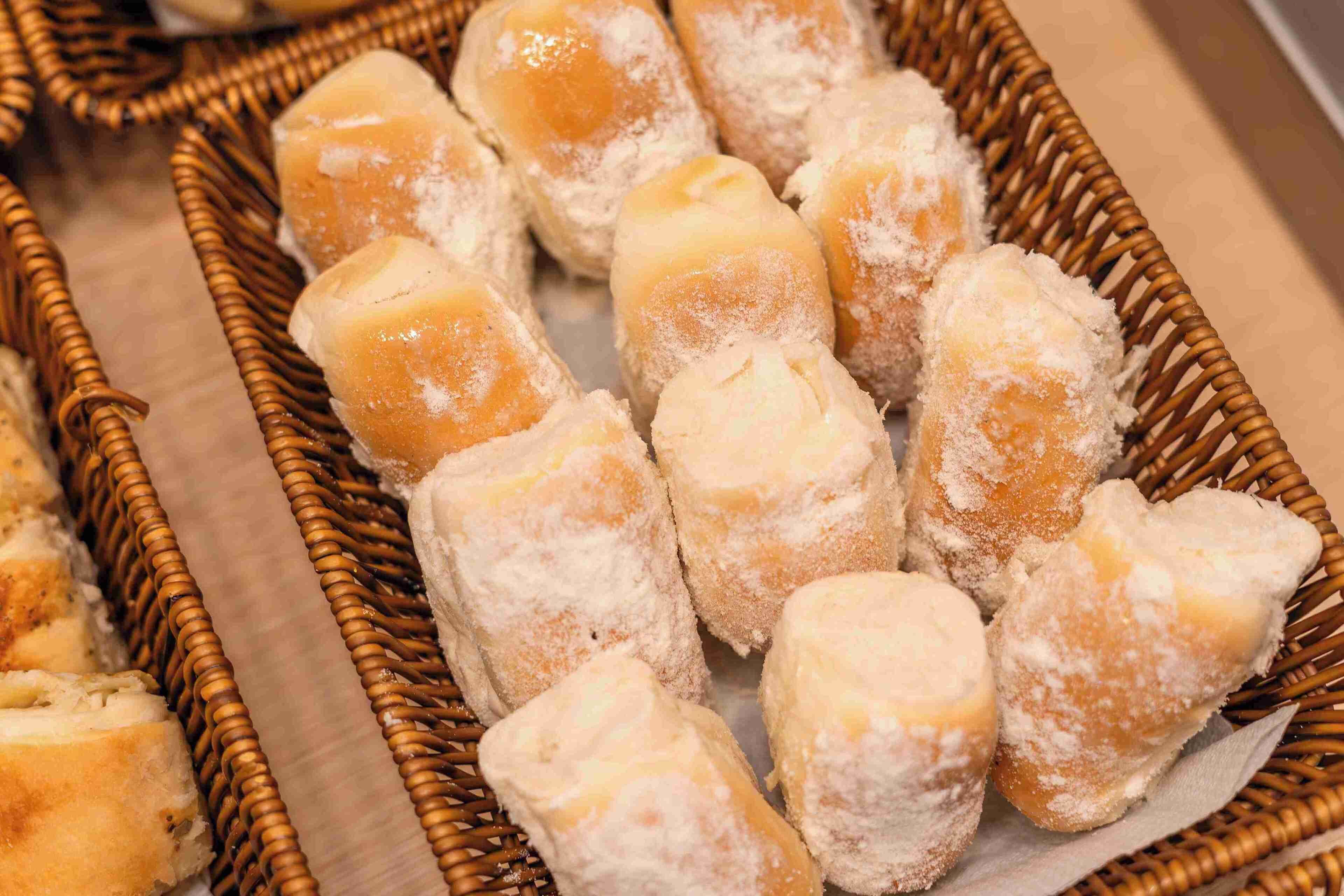 A basket of pastries dusted with powdered sugar.