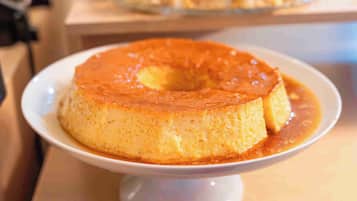 A caramel flan on a white plate.