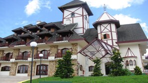 A traditional building with multiple balconies, stone walls, and a prominent tower. - Hotel Nacional Inn Campos do Jordão (Campos do Jordão)