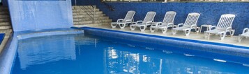 Una piscina techada, sillones reclinables de piscina