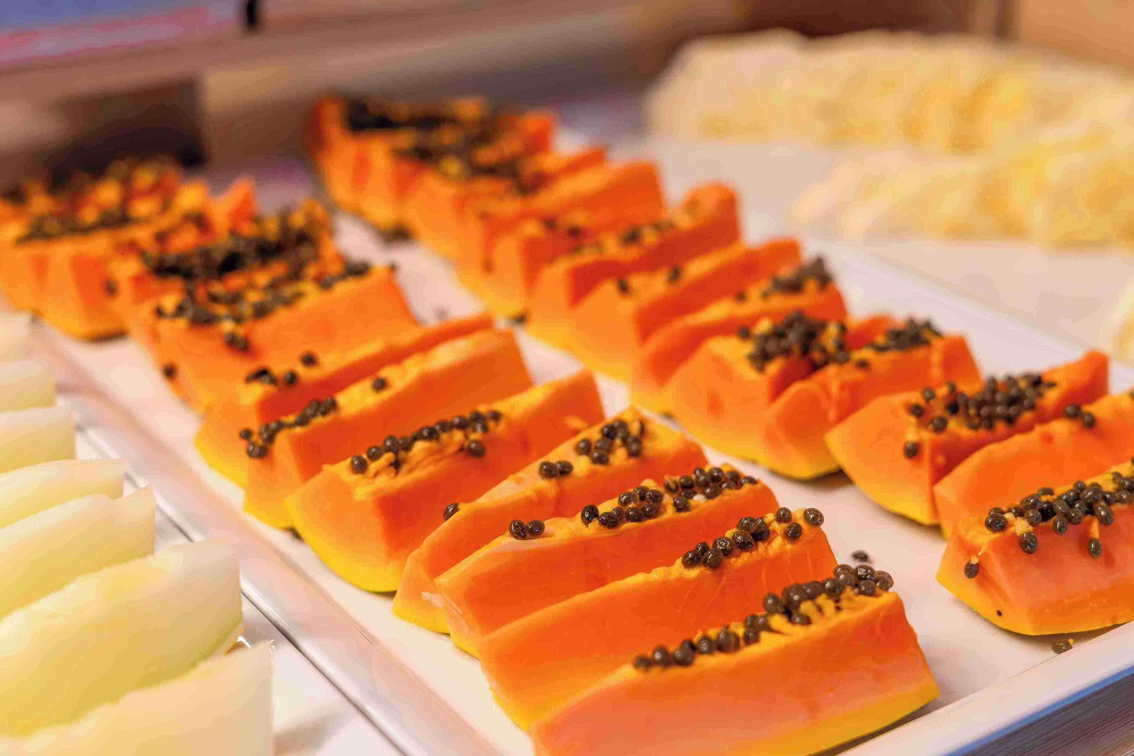 Una bandeja con papaya cortada en rodajas.