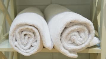 Two rolled white towels on a shelf.