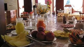 A breakfast buffet with various fruits, pastries, and beverages. - Pousada Jóia da Serra (Campos do Jordão)