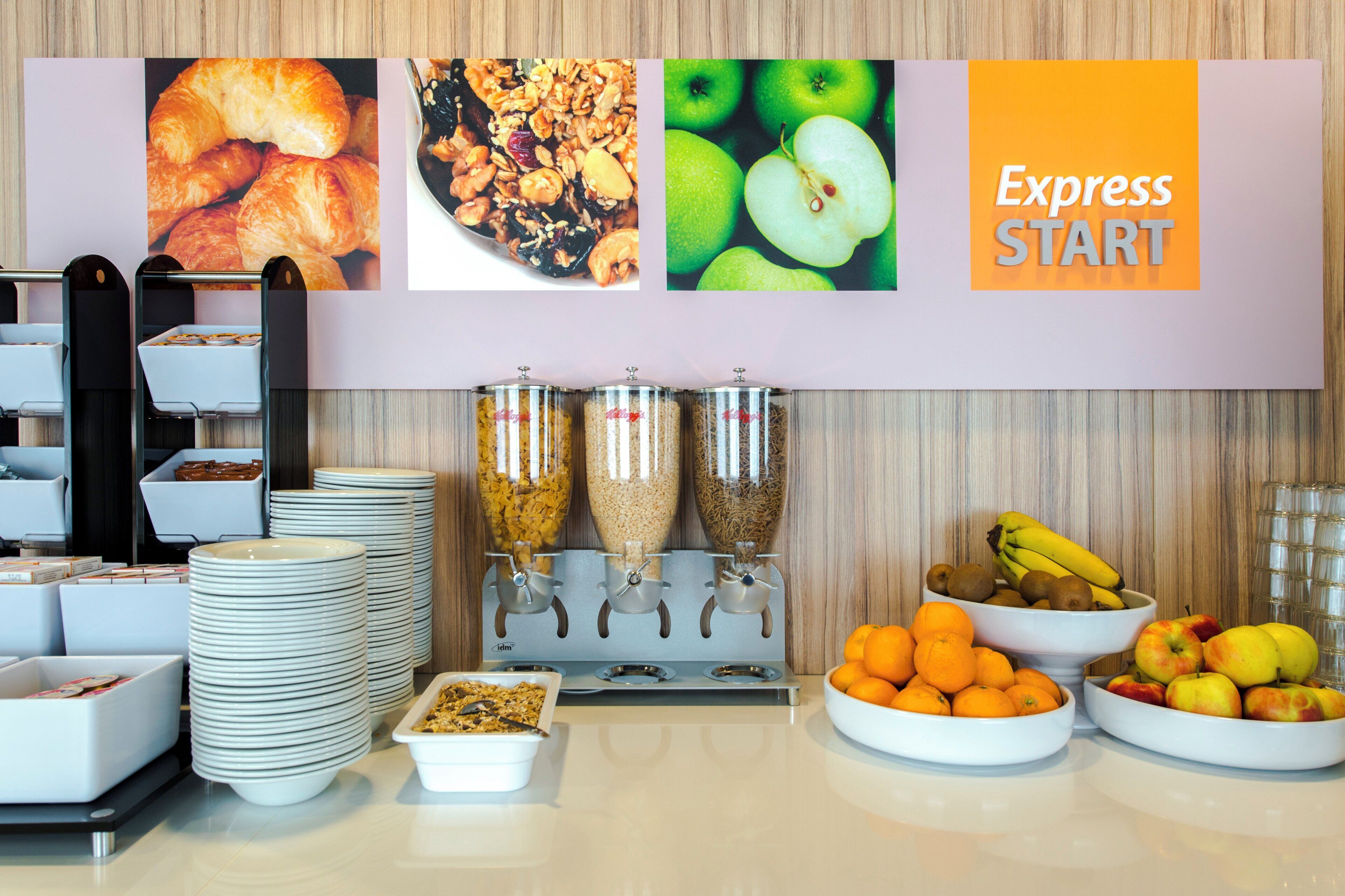 A breakfast buffet setup with various food items and a sign that reads 'Express START'.