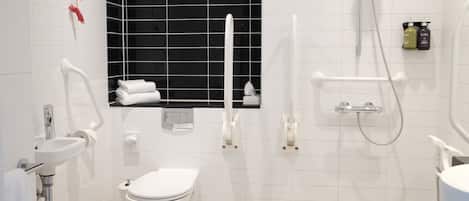 A modern bathroom with a white toilet, a sink, a shower, and a black-framed window.
