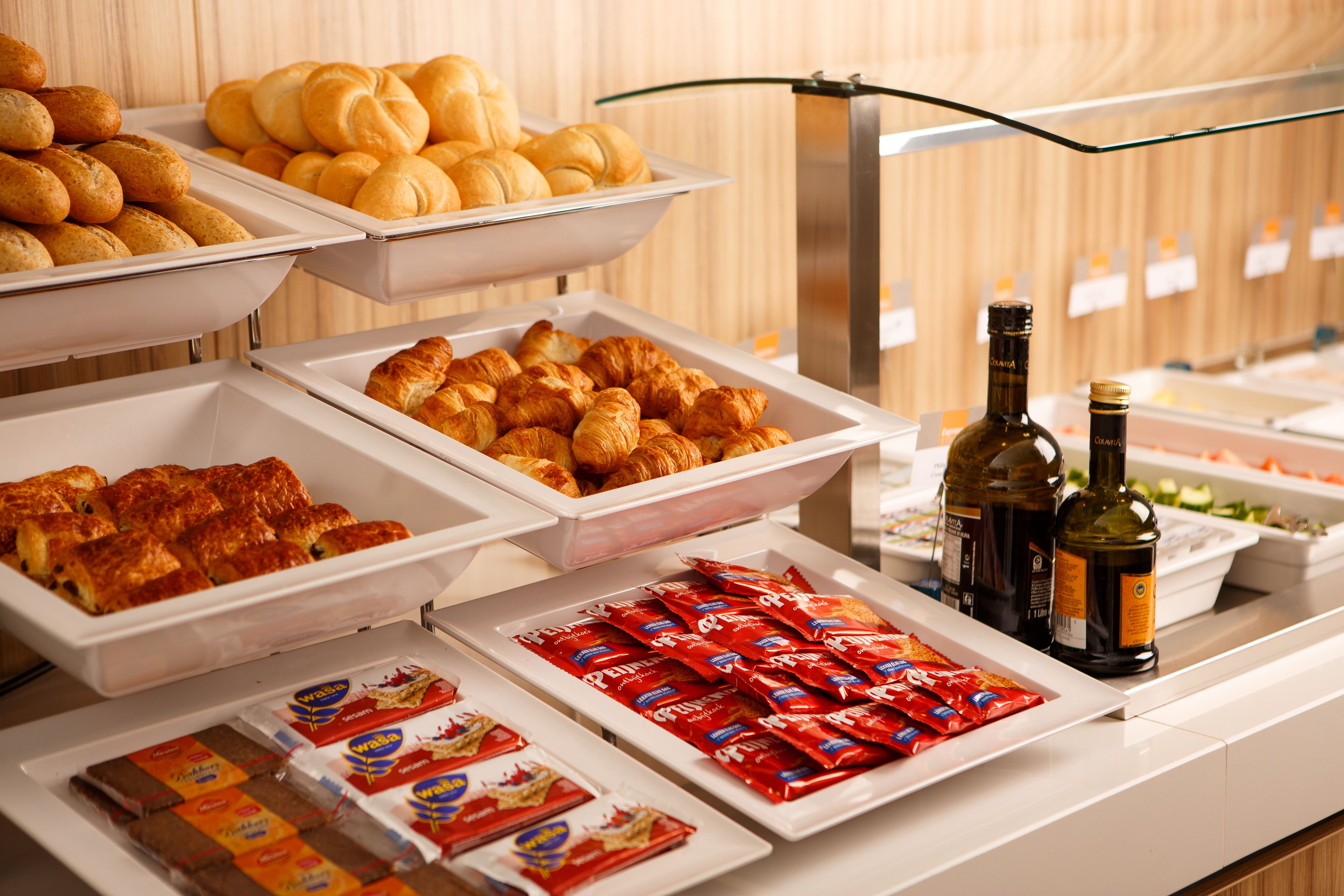 Un buffet proposant une variété de plats, notamment des pâtisseries, des sandwichs et des accompagnements.