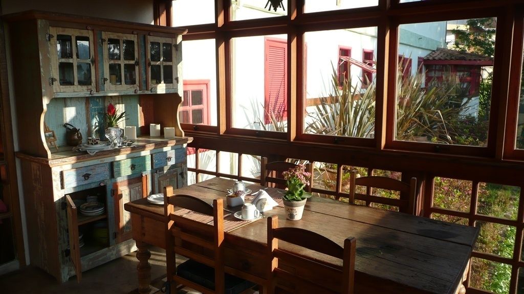 Une cuisine rustique avec des meubles en bois et une grande fenêtre donnant sur un jardin.