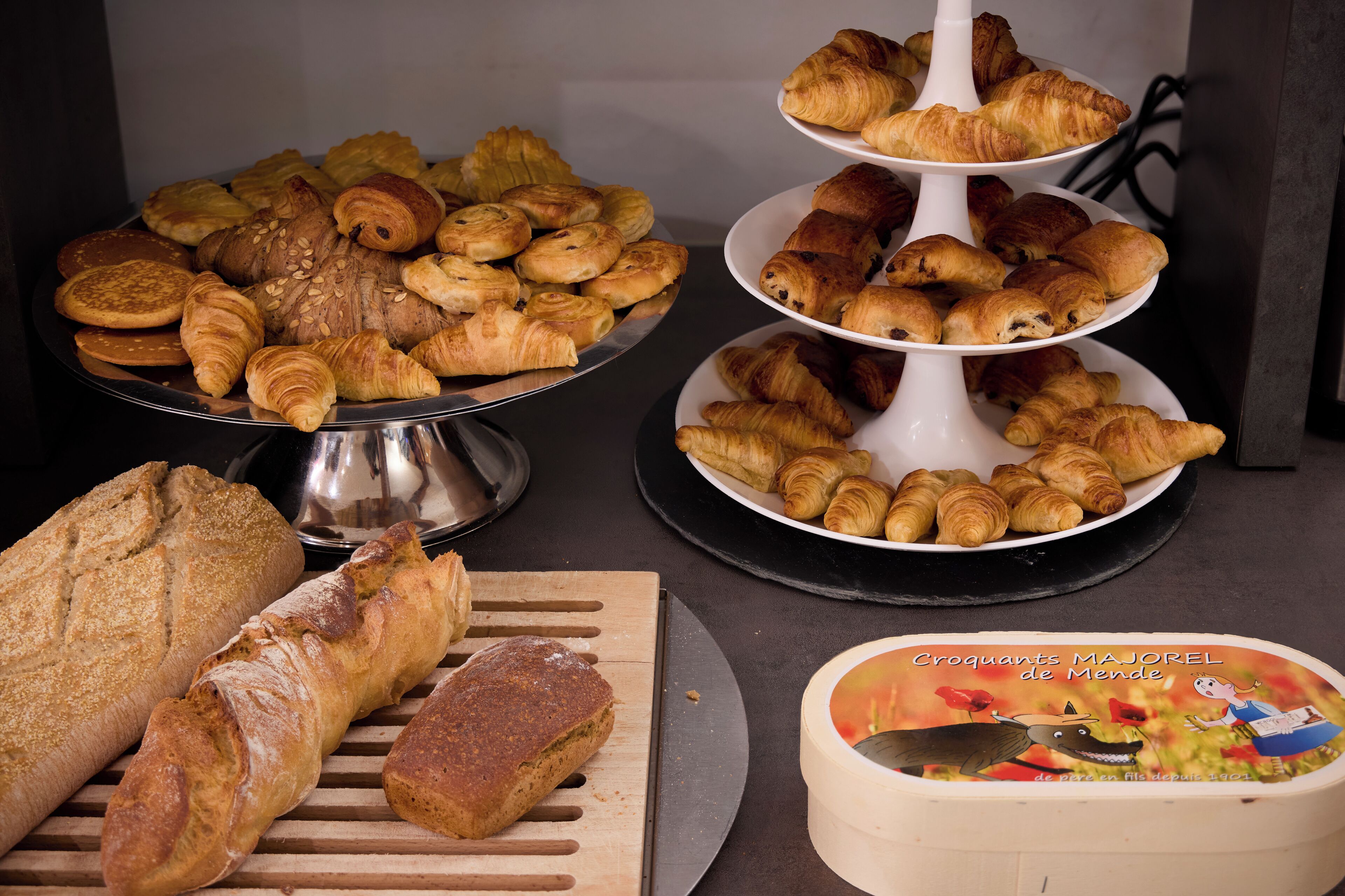 Ett urval av bakverk, inklusive bröd, croissanter och andra söta bakelser, som är uppradade på ett bord.