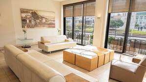 Uma sala de estar moderna com um sofá, uma mesa de centro e uma mesinha lateral de vidro.