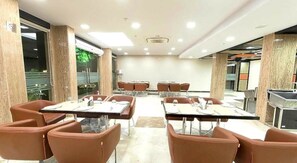 A conference room with tables and chairs, large windows, and a view of the outdoors. - Palm Springs Stays (New Delhi)