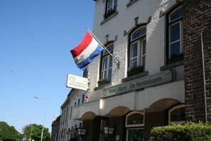 Hotel Garni De Karsteboom with a flagpole displaying the Dutch flag.