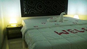 A neatly made bed with a white bedspread and a swan-shaped pillow. - Azoush Tourist Guesthouse (Fulhadhoo)