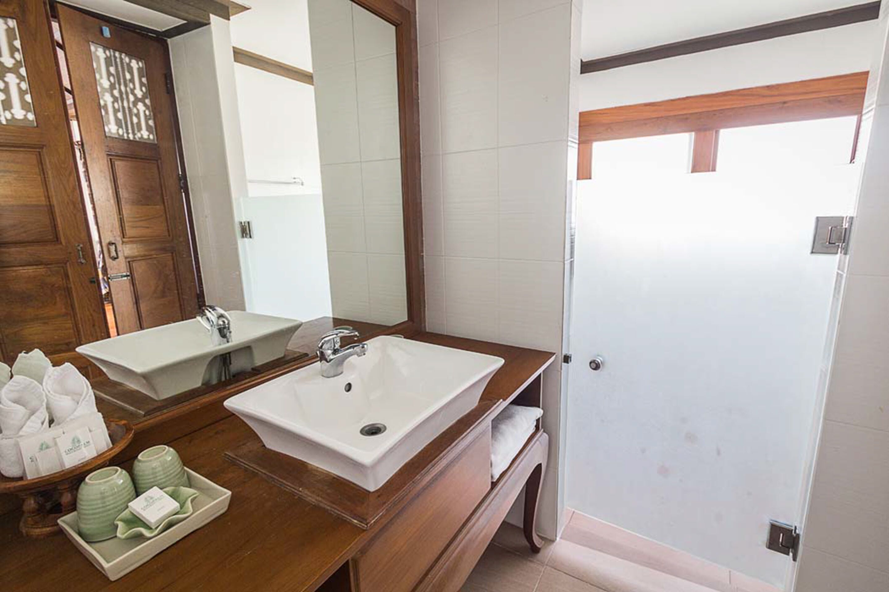 A bathroom with two sinks, a mirror, and a shower.