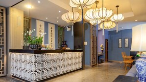 A reception area with a decorative counter, hanging lanterns, and traditional decor. - Sino Inn (Phuket)
