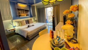 A hotel room with a bed, bedside table, lamp, and a view of the outside. - Sino Inn (Phuket)