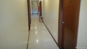 Un couloir d’hôtel avec des portes numérotées 205, 206 et 207, donnant accès aux chambres.