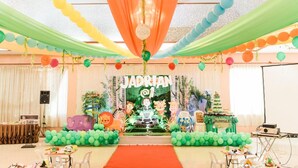 Un espacio interior decorado con un escenario que presenta temática de 'JADRIAN SAFARI', incluyendo siluetas de animales y follaje.
