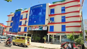 Un edificio de varios pisos con un cartel llamativo del Hotel Plaza.