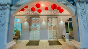 A hotel entrance with a decorative archway, two doors with intricate designs, and a sign reading "SINO IMPERIAL". - Sino Imperial Design Hotel (Phuket)