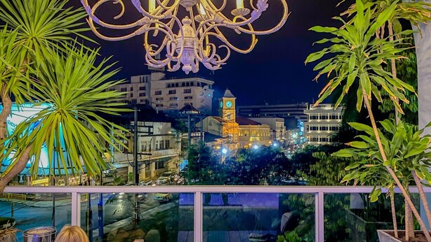 A balcony with a view of a cityscape at night, including a clock tower. - Sino Imperial Design Hotel (Phuket)