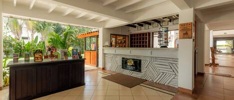 A reception area with a counter, a fireplace, and a view of the outdoors.