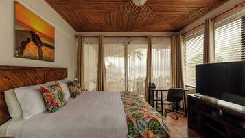 Une chambre d’hôtel avec un lit, une télévision, un bureau et une fenêtre avec des rideaux.