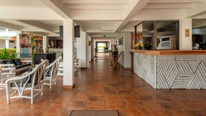 A hotel lobby with a reception desk, seating area, and a long corridor leading to other rooms. - Jacó Laguna Resort and Beach Club (Jacó)