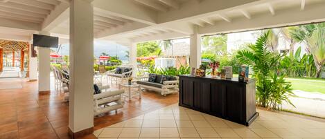 A spacious lobby with a reception desk, seating area, and large windows offering views of the outdoors.