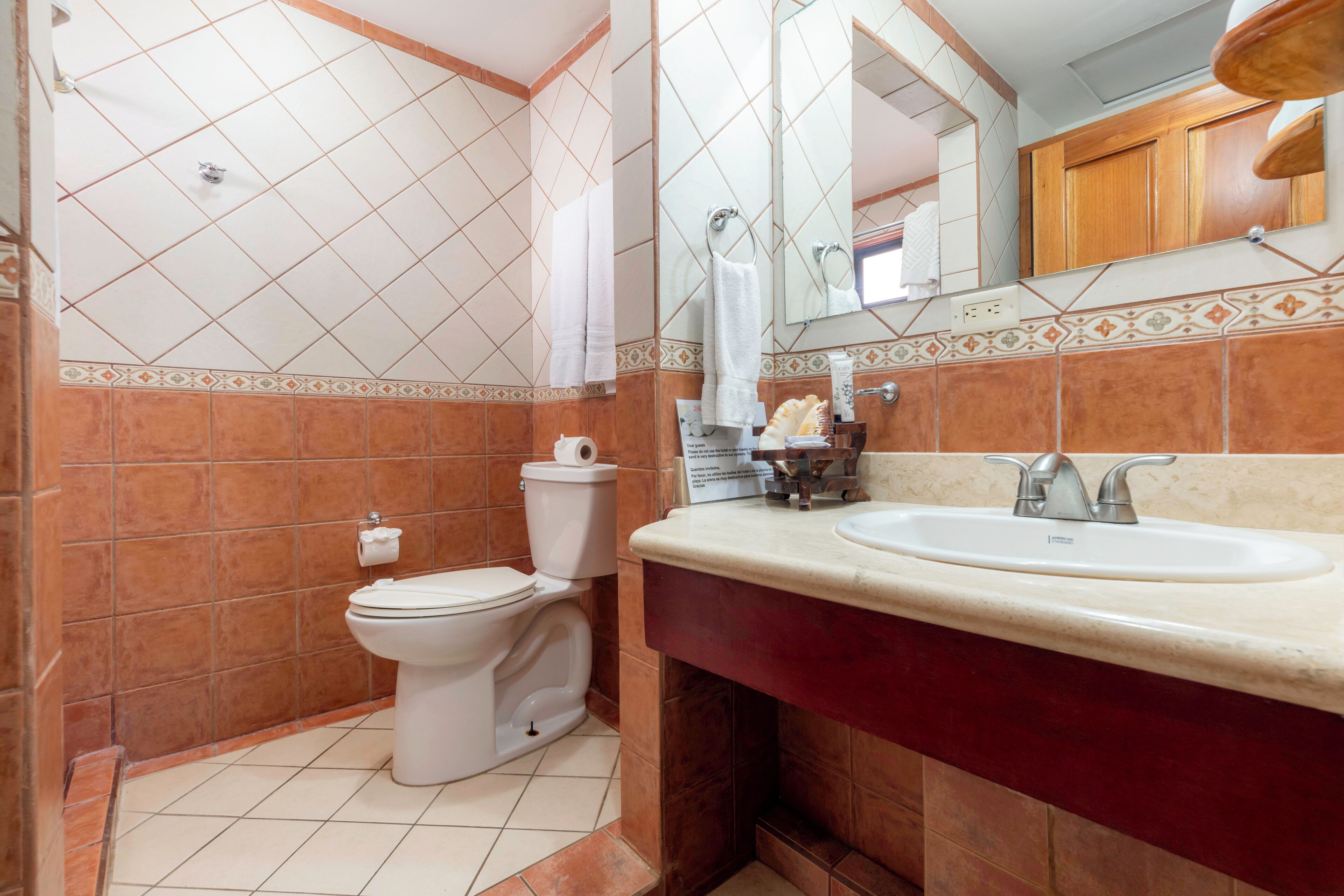 Ein Badezimmer mit Toilette, Waschbecken und Spiegel.