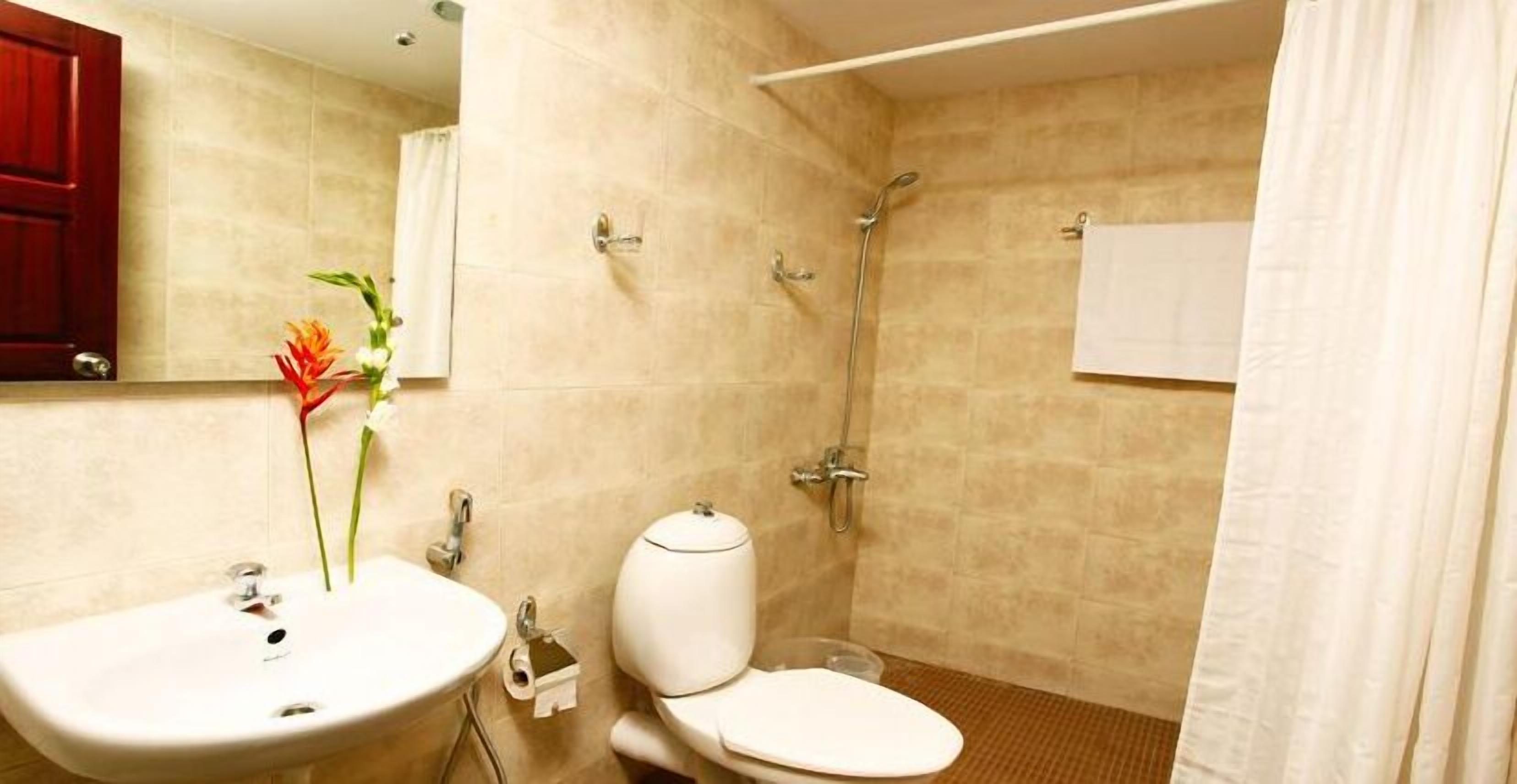 A bathroom with a sink, toilet, and shower.