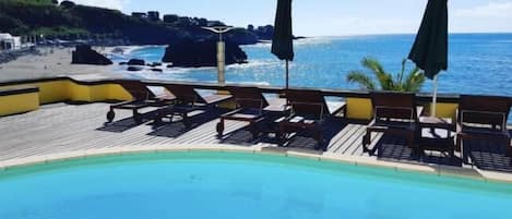 Alberca al aire libre y camastros