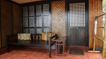 A traditional room with a wooden bench, a small table, and a door with a number.