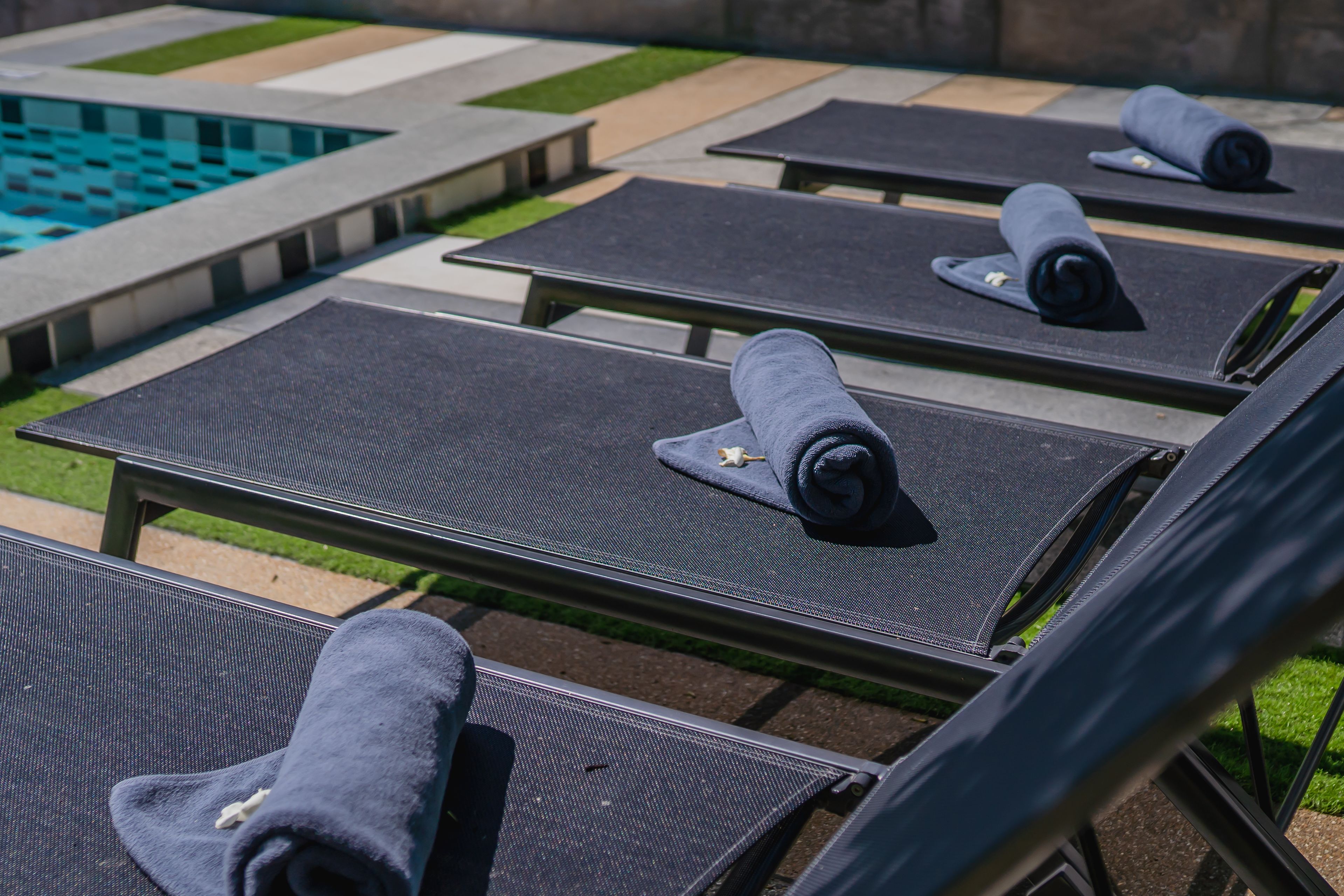 A poolside area with lounge chairs and towels.