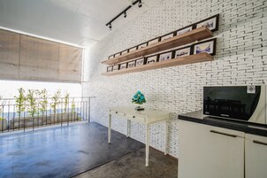Una cocina moderna con armarios blancos, encimera negra y un refrigerador Samsung.