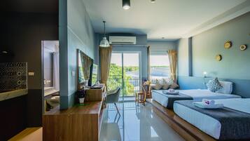A modern hotel room with a balcony, a desk, a bed, and a seating area.