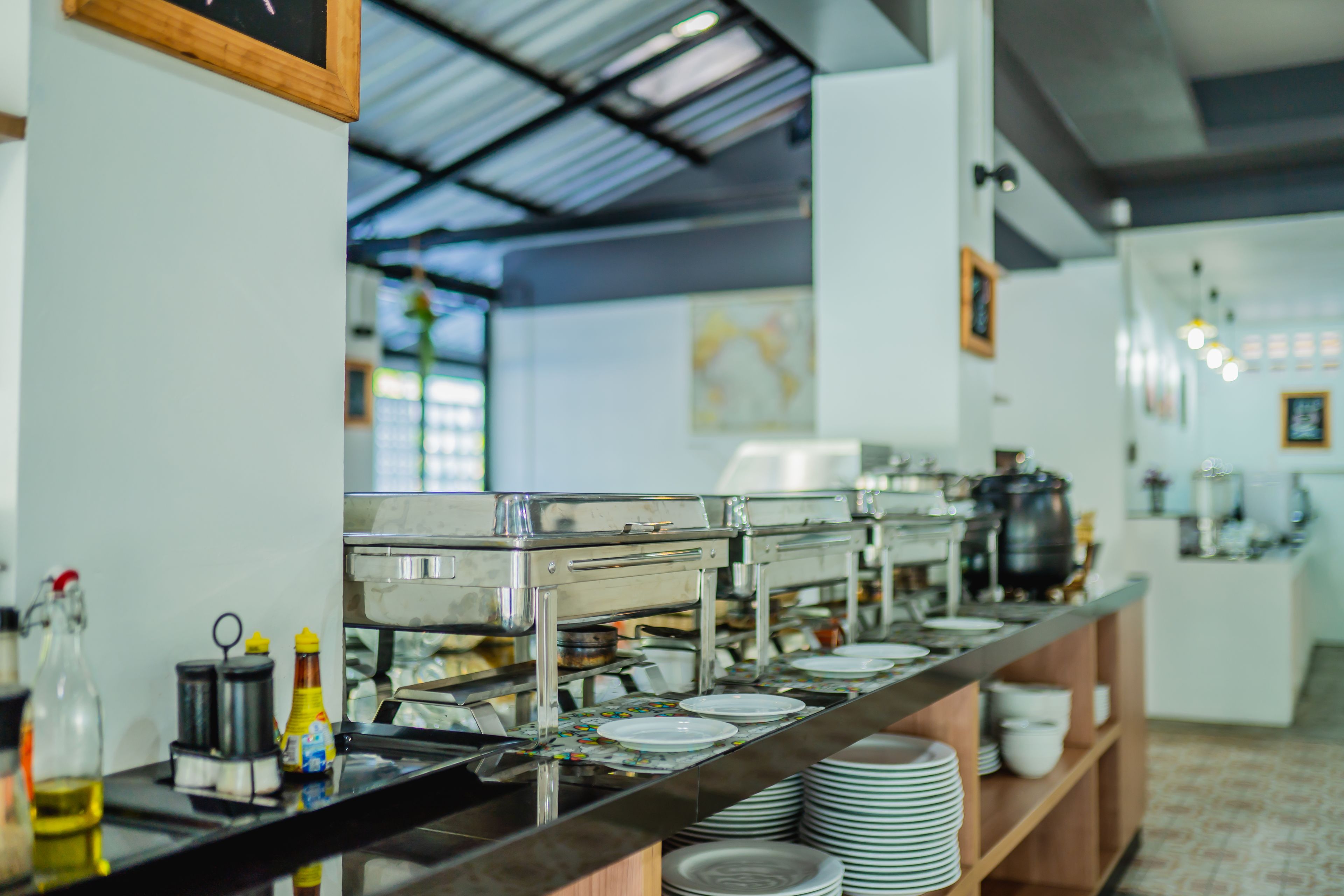 A buffet setup with multiple serving stations, a variety of condiments, and stacked plates.