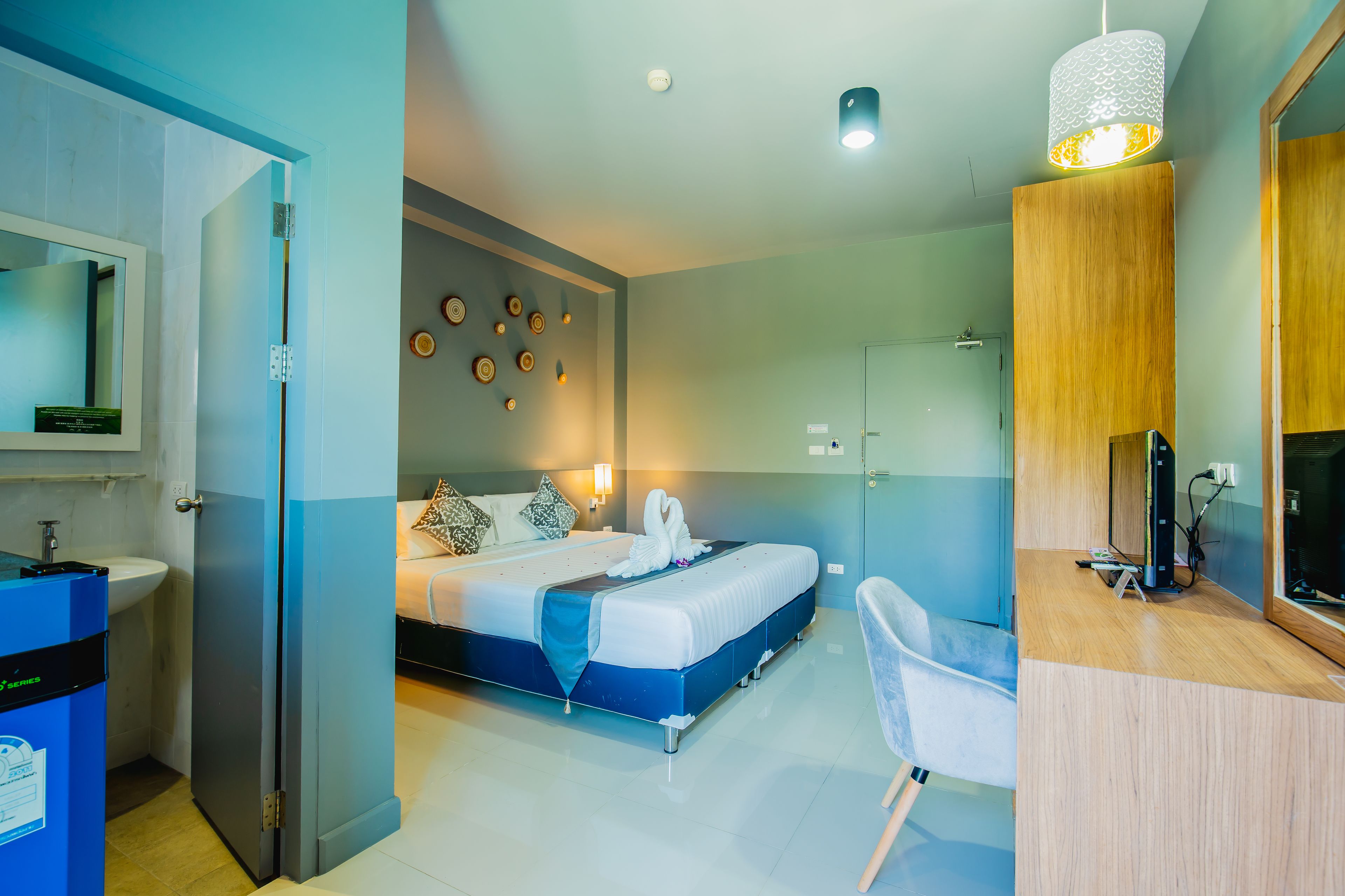 Una habitación de hotel moderna con cama, escritorio y baño.