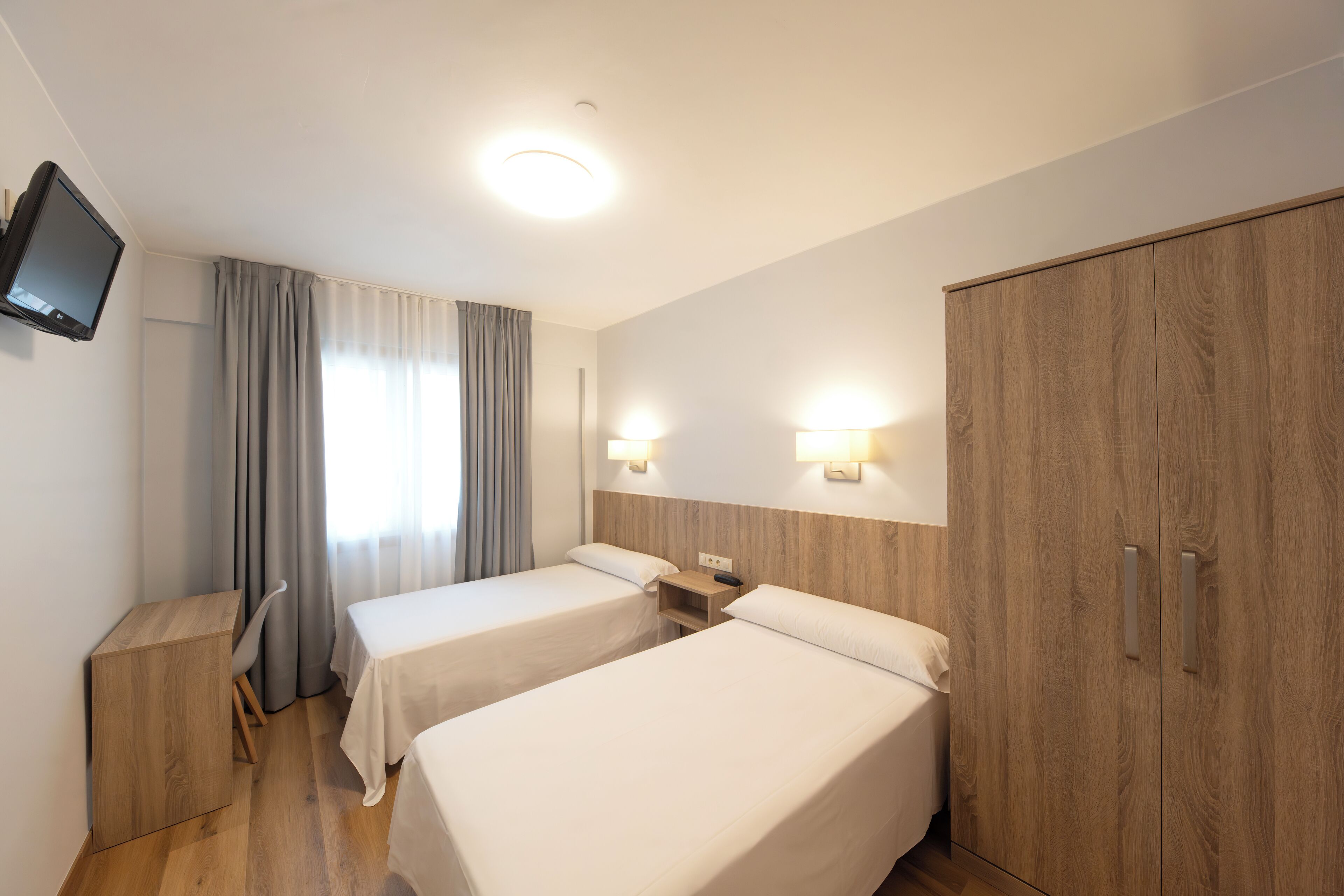 twin room | desk, laptop workspace, blackout curtains, iron/ironing board