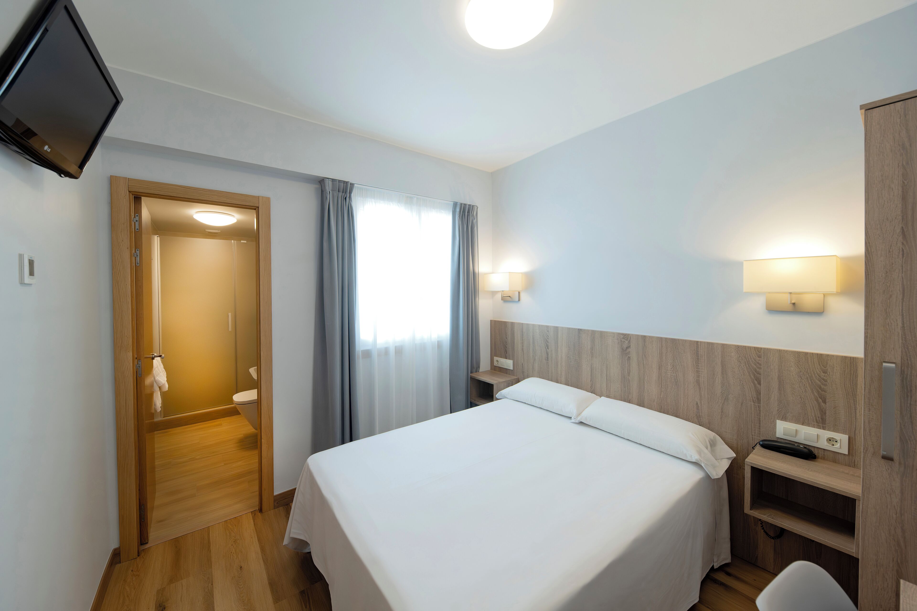 economy double room | desk, laptop workspace, blackout curtains, iron/ironing board