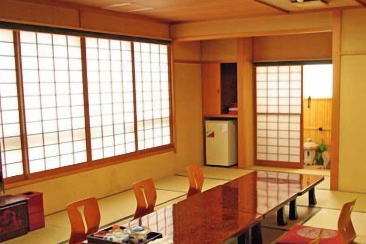 A traditional Japanese-style room with tatami flooring, a low table, and sliding doors.