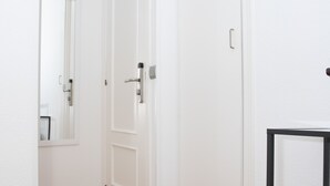 Eine weiße Tür mit silbernem Griff und einem kleinen schwarzen Gegenstand an der rechten Wand.